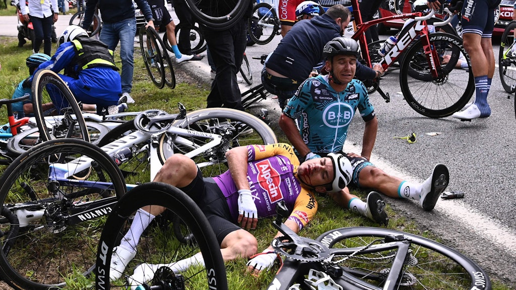 Mehrere Fahrer liegen nach dem Massensturz während der ersten Etappe der Tour de France verletzt am Straßenrand.