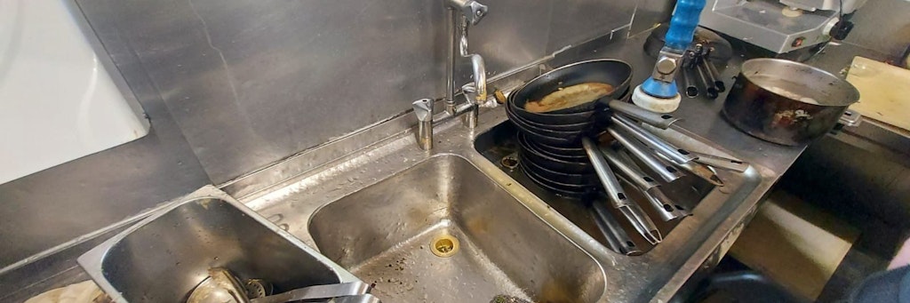 Ölverschmierte Pfannen stapeln sich in der Spüle, Fettspritzer, wohin man schaut: Diese Restaurant-Küche bleibt nun kalt.