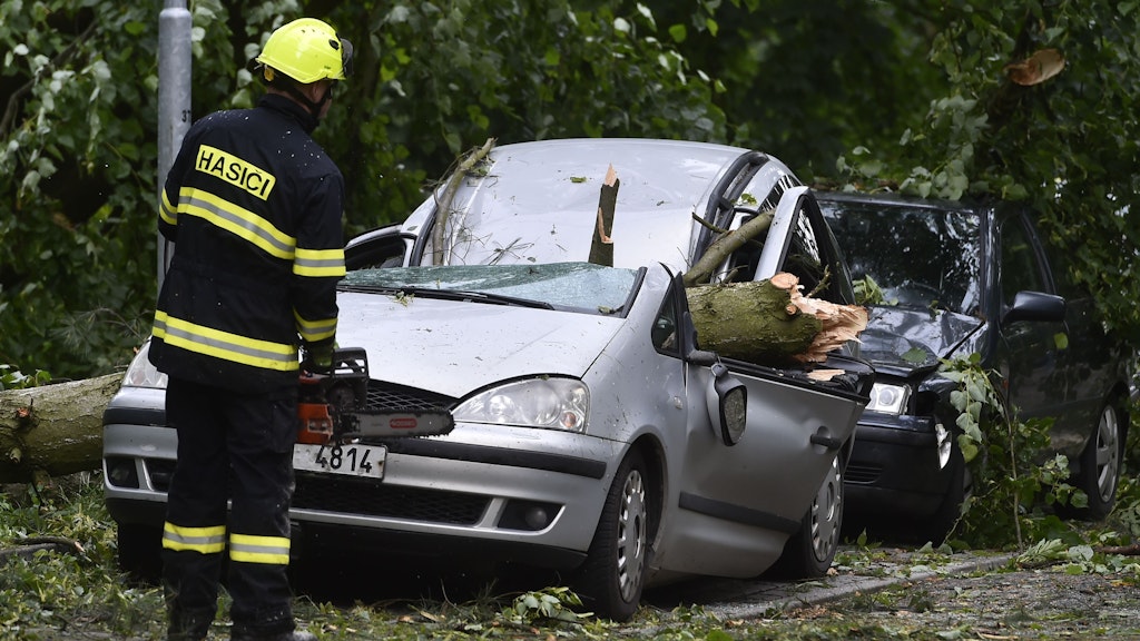 30.06.2021, Tschechien, Jihlava: Feuerwehrleute sind im tschechischen Jihlava im Einsatz, wo während eines nächtlichen Sturms Bäume auf geparkte Autos fielen.