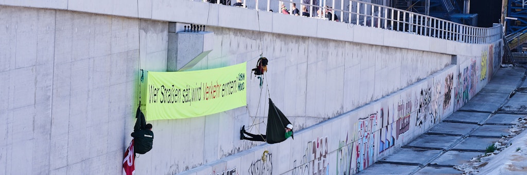 „Wer Straßen sät, wird Verkehr ernten“ steht auf dem Banner, das „Robin Wood“- Aktivisten auf dem abgesperrten Gelände an der Baustelle der Autobahn A100 an der Sonnenallee aufhängen.