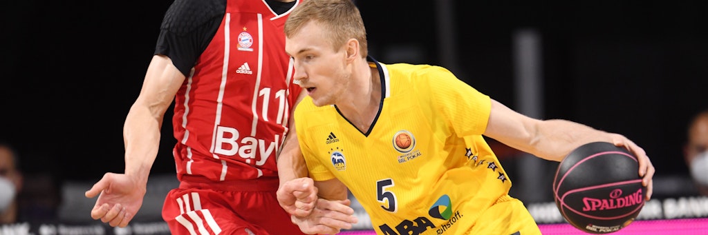Albas Niels Giffey quetscht sich um Bayern-Star Vladimir Lucic herum.