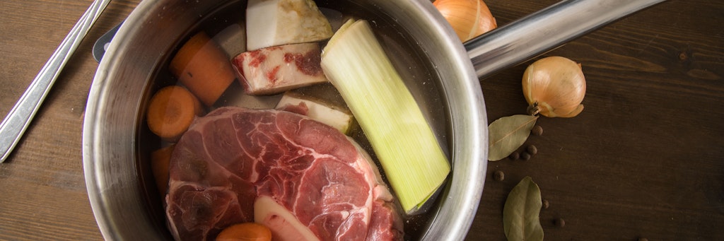 Knochenstücke vom Rind werden über viele Stunden knapp unter dem Siedepunkt ausgekocht. Wer mag, gibt frisches Gemüse dazu. 