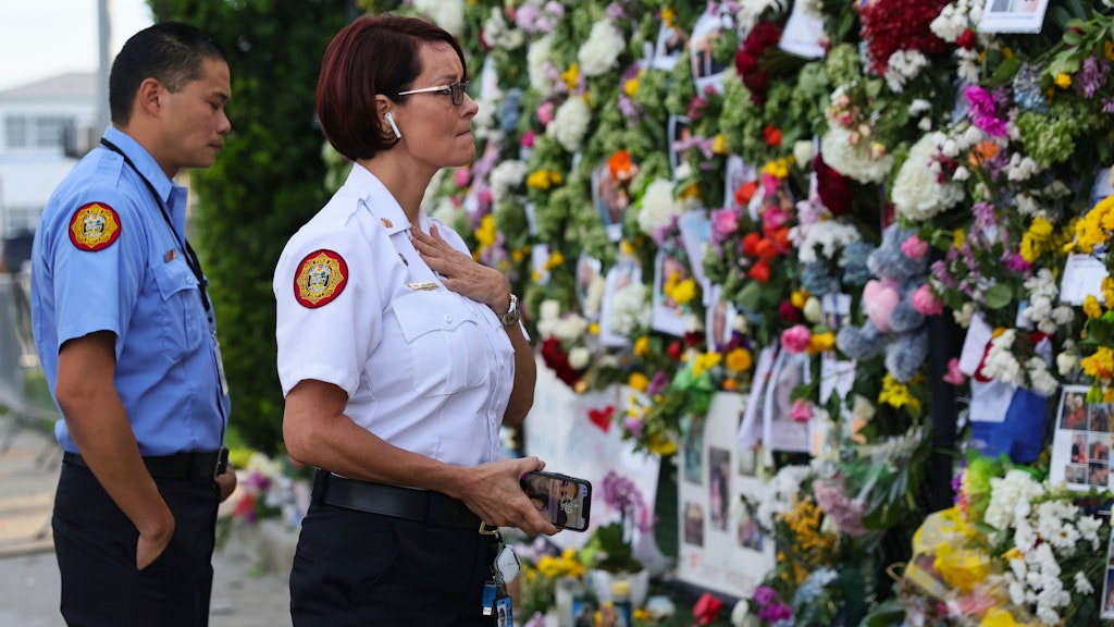 Feuerwehrleute vom Miami-Dade bei einem Besuch der Gedenkstätte für die Toten, Vermissten und Verschütteten des eingestürzten Hochhauses. 