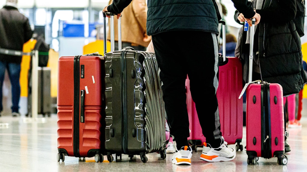 Reisende warten in einer Schlange am Check-in für einen Flug nach Mallorca am Flughafen Hannover-Langenhagen.