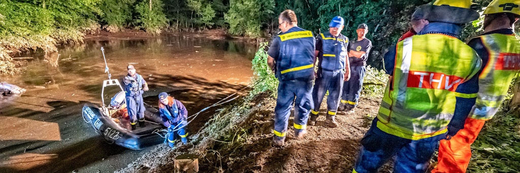 Rettungskräfte sichern einen Teich bei Fröndenberg dessen Deich durch sintflutartige Regenfällen aufgeweicht wurde und zu brechen droht. 