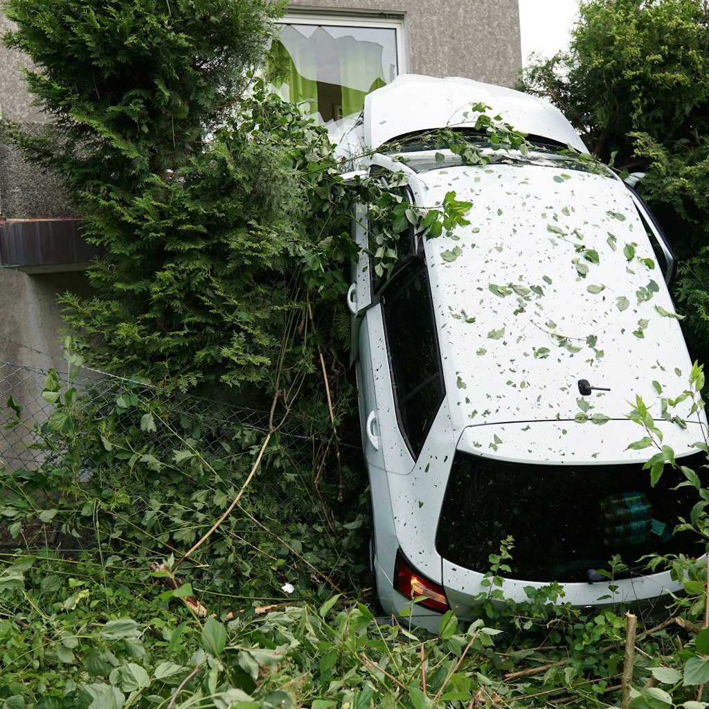 Ein Auto hängt auf einem Balkon eines Wohnhauses in Bad Driburg im NRW-Kreis Höxter. Eine 31-Jährige war mit dem Auto von der Straße abgekommen, in die Luft geschleudert worden und gegen das erste Obergeschoss des Wohnhauses geknallt. 