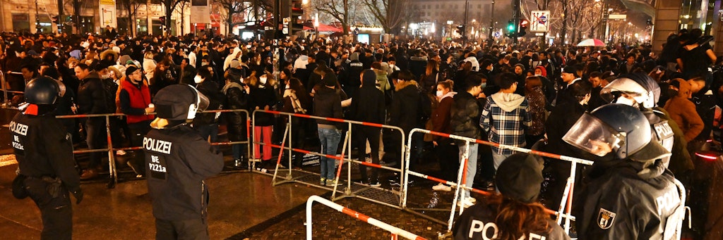 Polizisten stehen hinter einer Absperrung am Brandenburger Tor, wo sich mehrere hundert Menschen versammelt haben.