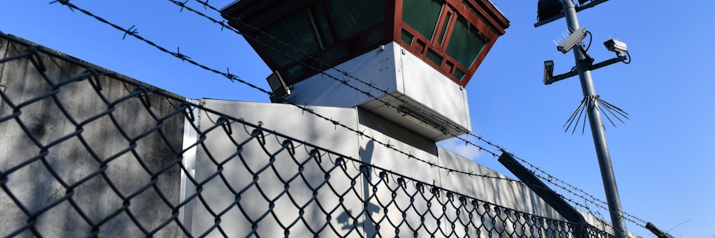 Sicherheitsleuchten und Überwachungskameras sind vor einem Gebäude auf dem Gelände der Justizvollzugsanstalt Tegel zu sehen. 