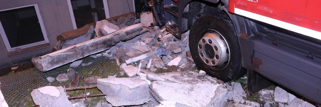 Berlin-Altglienicke: Mauerteile liegen zwischen dem Lkw und dem Gebäude.