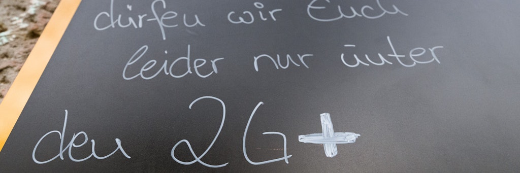 Auf einem Schild vor einem Lokal wird auf die 2G-plus-Regel hingewiesen. 