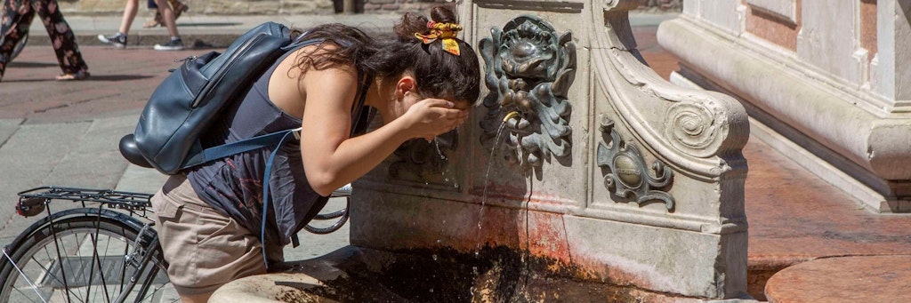 Eine Frau erfrischt sich im italienischen Bologna einem Brunnen. Das vergangene Jahr war das siebte Jahr in Folge mit Temperaturen, die mehr als ein Grad über dem vorindustriellen Niveau lagen, so die Weltwetterorganisation WMO. 