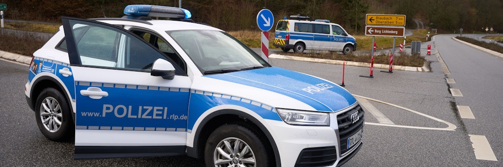 Rheinland-Pfalz, Kusel: Polizeibeamte sperren die Zufahrt zum Tatort, wo zwei Polizeibeamte bei einer Verkehrskontrolle erschossen wurden.