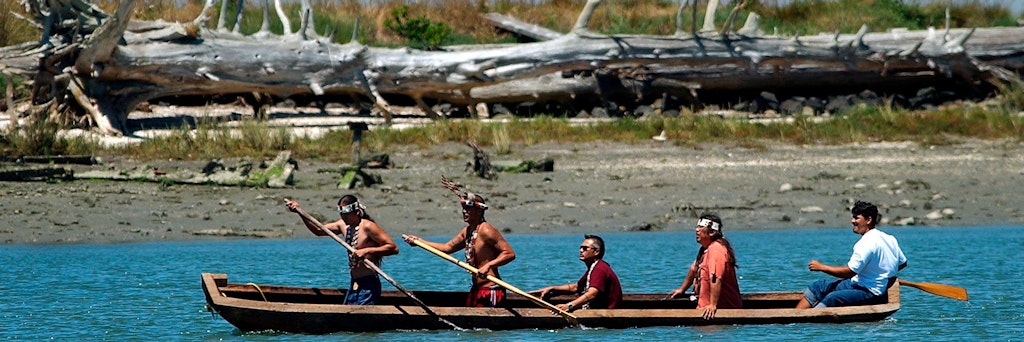 Indianer vom Stamm der Wiyot paddeln auf einem Einbaum durch die Humboldt Bay, sie sind die Ureinwohner.