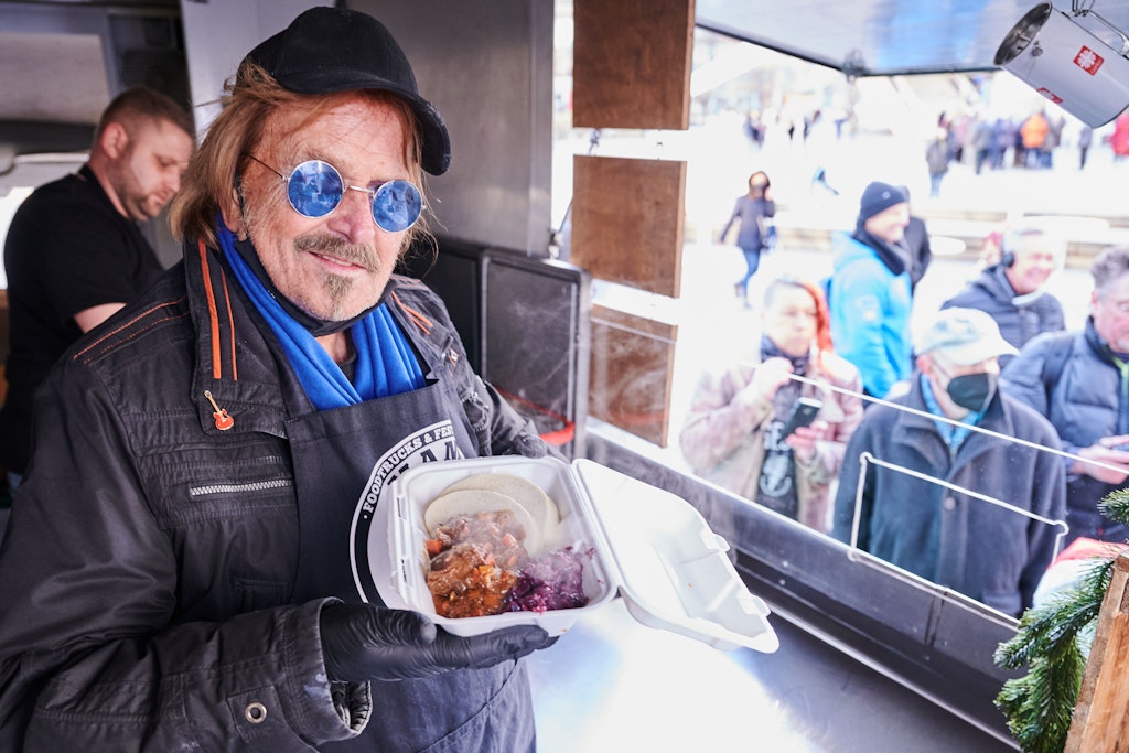 Frank Zander steht im Caritas-Foodtruck und verteilt warme Mahlzeiten an Obdachlose und bedürftige Menschen auf dem Alexanderplatz.