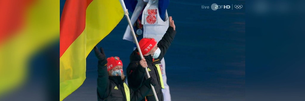 Claudia Pechstein und Francesco Friedrich tragen die Fahne für Deutschland ins Olympiastadion von Peking.