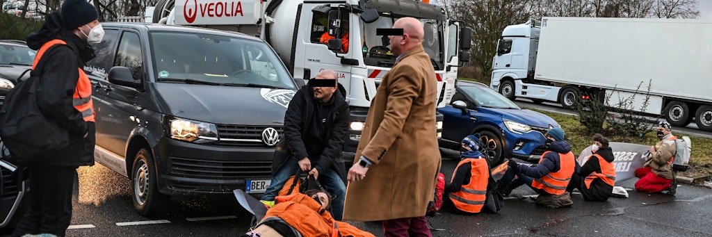 Mehrere Autofahrer zerren Klimaschützer mit Gewalt von der Straße.