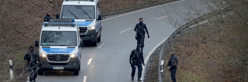 Polizeibeamte suchen nach dem Mord an zwei Polizisten am Tatort nach Spuren.
