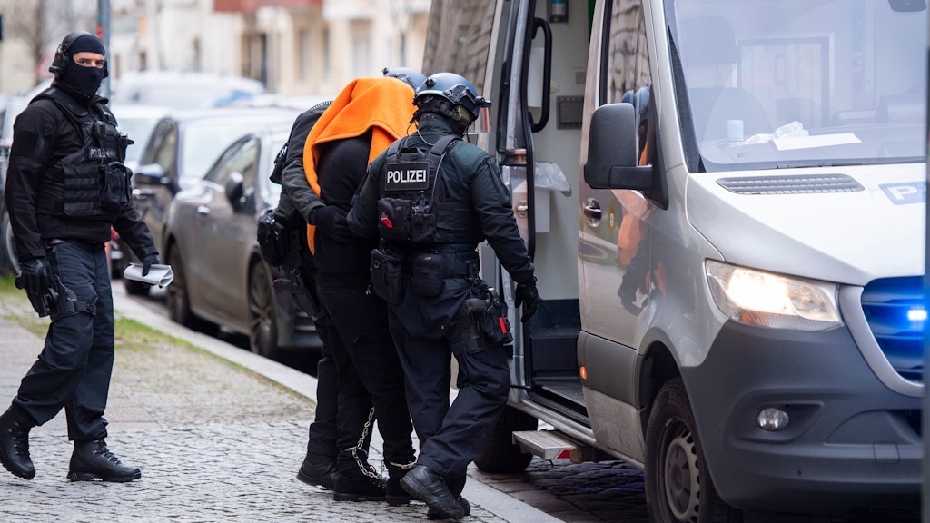 Der Angeklagte wird in einen Polizeitransporter gebracht.