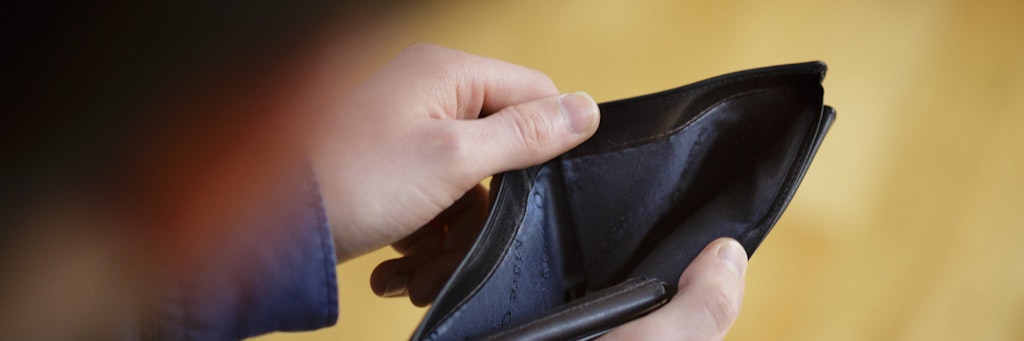 Eine Person schaut in eine leere Brieftasche. Dank der kräftigen Inflation ist am Ende des Geldes immer so viel Monat übrig.