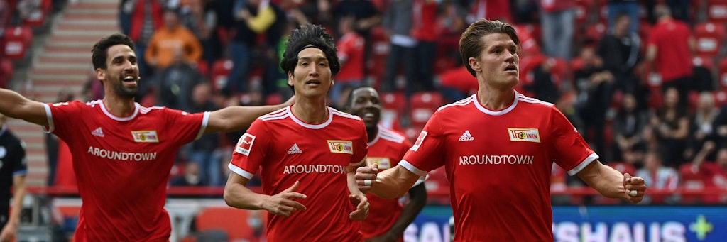 So sehen Sieger aus! Kevin Behrens (r.) jubelt nach seinem später Siegtreffer gegen die Arminia, Rani Khedira und Genki Haraguchi versuchen ihn zu fangen.