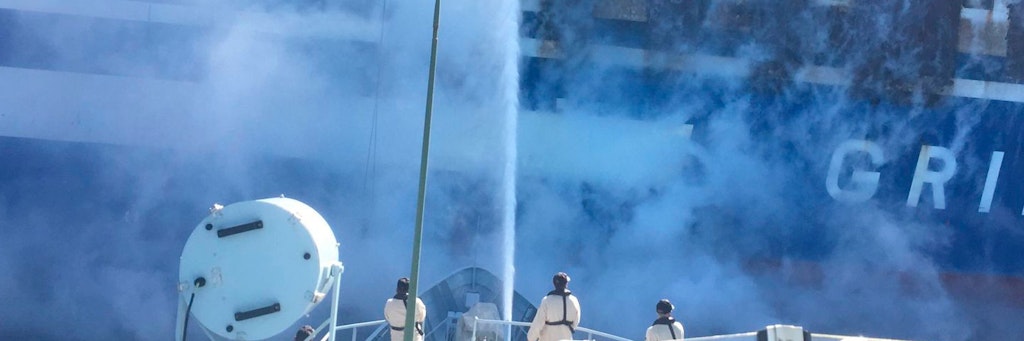 Feuerwehrleute löschen das Feuer, während schwarzer Rauch aus der brennenden Autofähre „Euroferry Olympia“ vor Korfu aufsteigt.