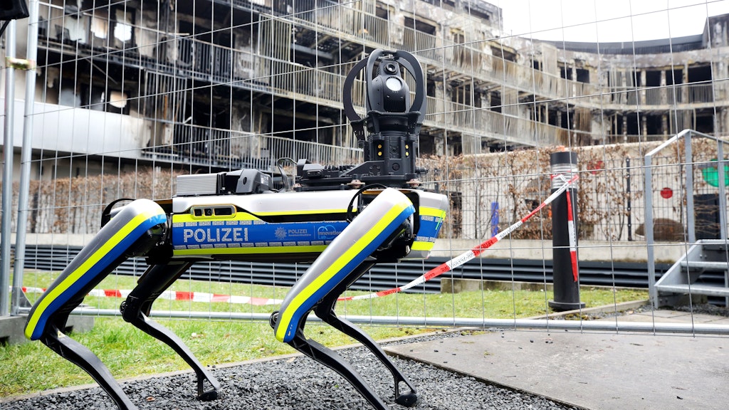 Ein Polizei-Roboter ist am ausgebrannten Wohnkomplex im Einsatz. Mit dem 35 Kilogramm schweren Laufroboter soll das einsturzgefährdete Gebäude nach dem Ende der Löscharbeiten erkundet werden.