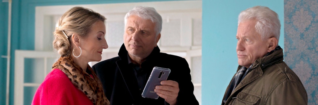 Die Tatort-Kommissare Franz Leitmayr (Udo Wachveitl) und Ivo Batic (Miroslav Nemec) zeigen einer Zeugin ein Foto.