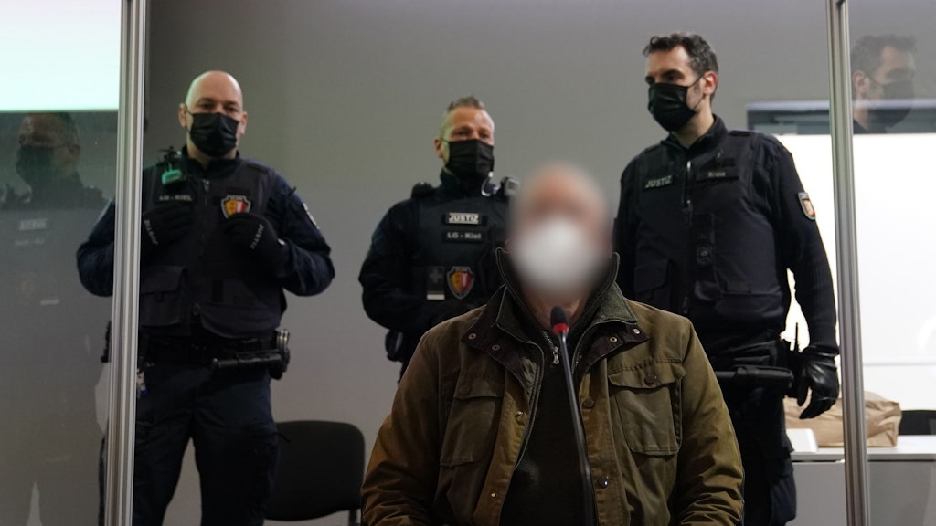 Der Angeklagte (vorne) zu Beginn des Prozesses wegen eines Dreifachmordes im Landgericht Kiel.