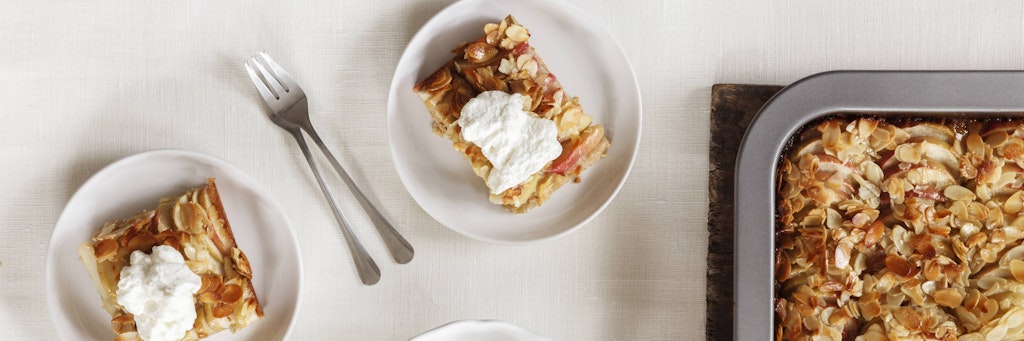 Den Blitz-Apfelkuchen servieren sie am besten mit geschlagener Sahne.
