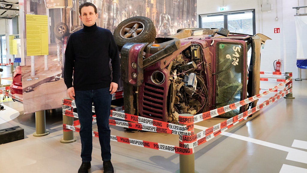Maximilian Warshitsky steht in der Ausstellung vor dem Jeep seines Vaters, in welchem dieser als Opfer der Kudamm-Raser 2016 ums Leben kam.