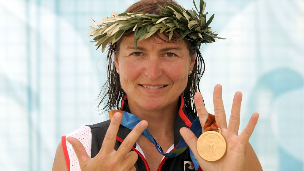 Birgit Fischer mit Lorbeerkranz auf dem Kopf und Gold um den Hals. 2004 in Athen paddelte die Kanu-Legende bei ihren 6. Olympischen Spielen zum achten Sieg.