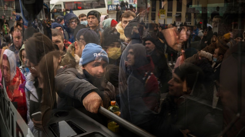 Menschen versuchen in einen Bus zu steigen, um Kiew zu verlassen.