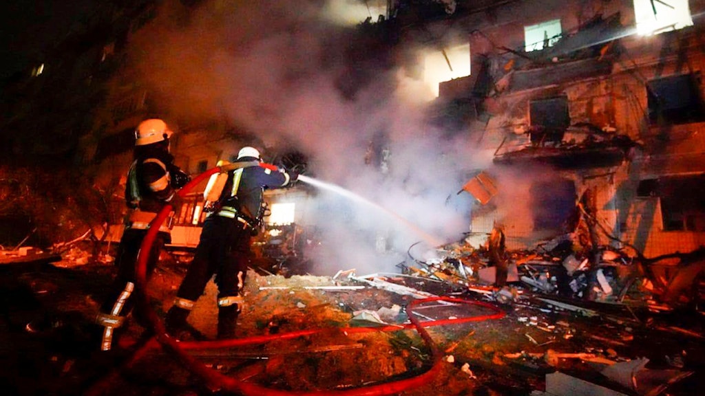 Feuerwehrleute löschen die Schäden an einem Gebäude nach einem Raketenangriff in Kiew.