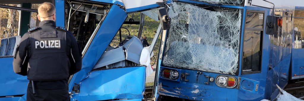 Nach dem Zusammenstoß von zwei Straßenbahnen in Rostock sichern Polizisten die Unfallstelle.