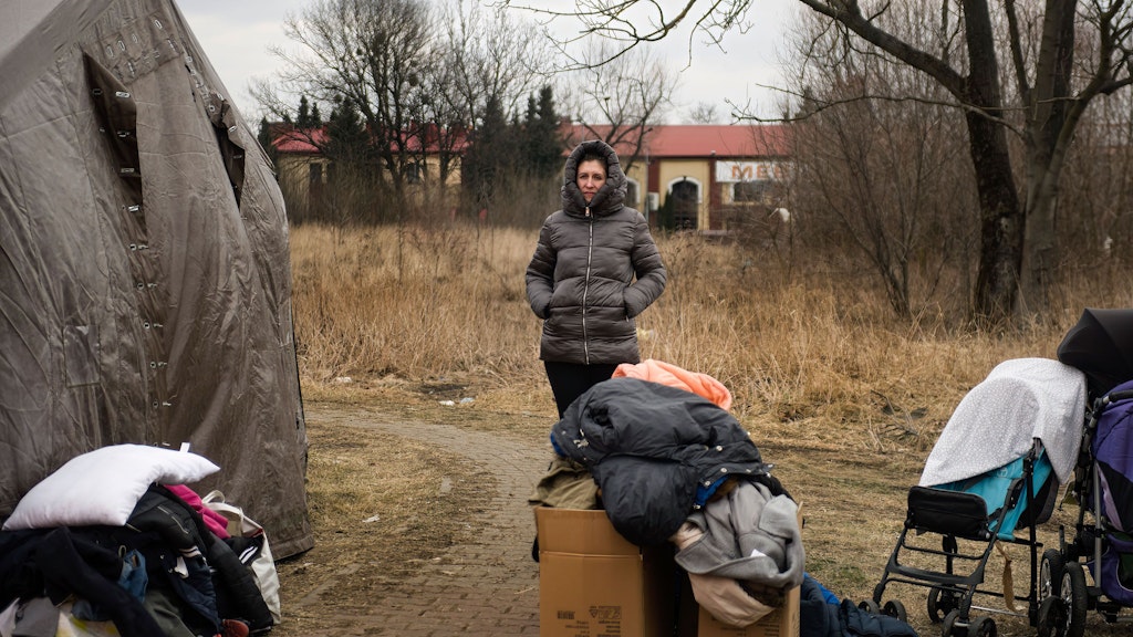 Eine ukrainische Frau steht neben ihren Habseligkeiten am humanitären Hilfspunkt in Przemysl. Tausende erschöpfter Kriegsflüchtlinge aus der Ukraine kommen täglich mit Bussen, Zügen und Autos in der polnischen Grenzstadt Przemysl an.