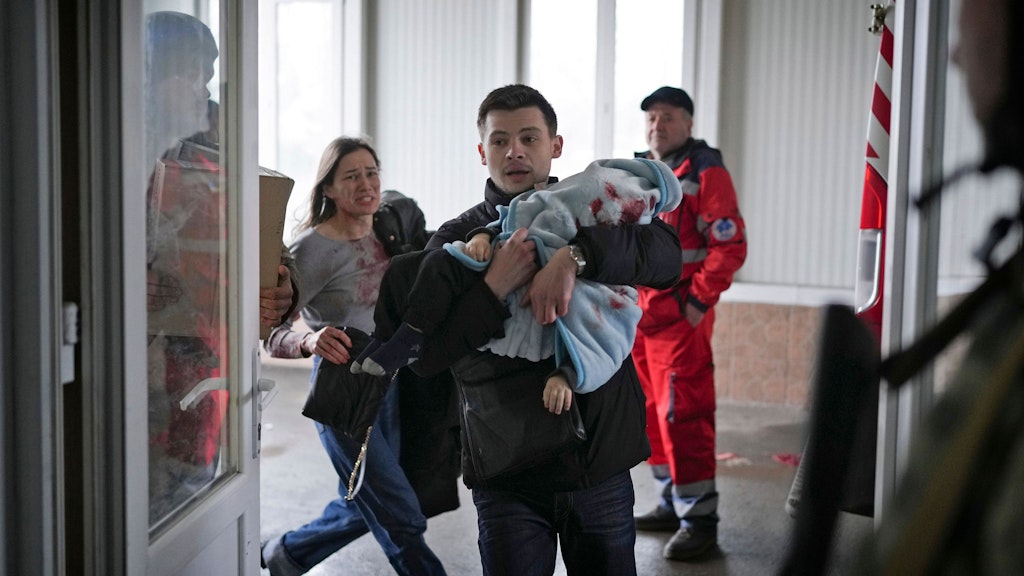 Vater und Mutter bringen ihren 18 Monate alten Sohn nach Raketenangriffen auf Mariupol in die Klinik.