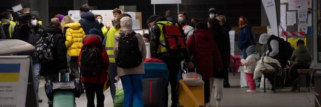 Flüchtlinge aus dem ukrainischen Kriegsgebiet gehen im Hauptbahnhof zu einer Sammelstelle.