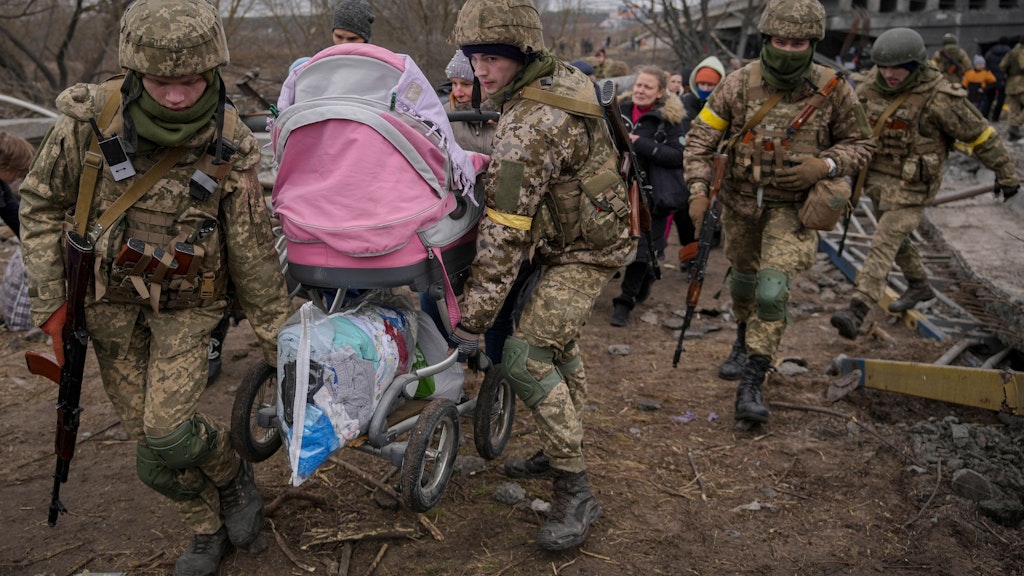 Ukrainische Soldaten helfen Zivilisten, aus Irpin zu entkommen.