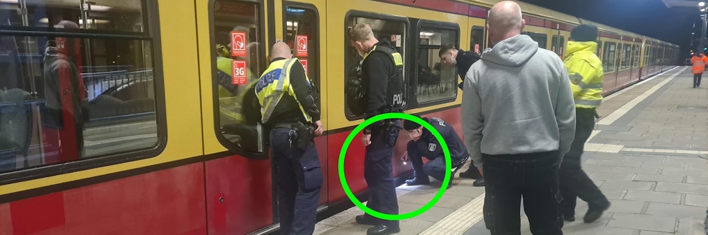 Nachts am S-Bahnhof Plänterwald: Ein Polizist leuchtet unter die S-Bahn, spricht mit dem Überfahrenen.