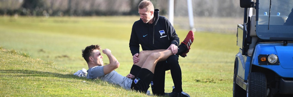 Herthas Verteidiger Fredrik Björkan wird von Physio Jürgen Lange behandelt.