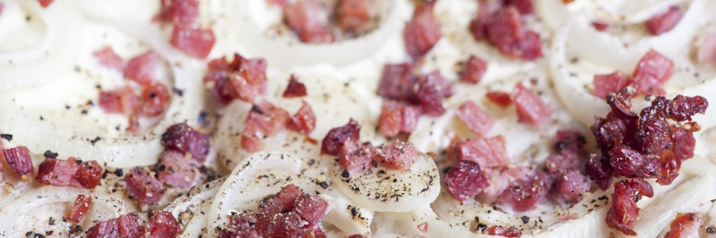 Mit Zwiebeln und Schinkenwürfeln wird der Flammkuchen perfekt. Mit dem Blumenkohlboden wird das Gericht zur leichten Alternative fürs Abendessen.