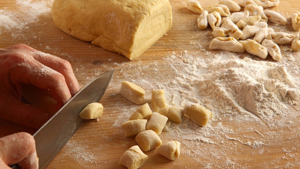 Gnocchi werden erst in Stücke geschnitten und dann mit Daumen und einer Gabel in Form gebracht.