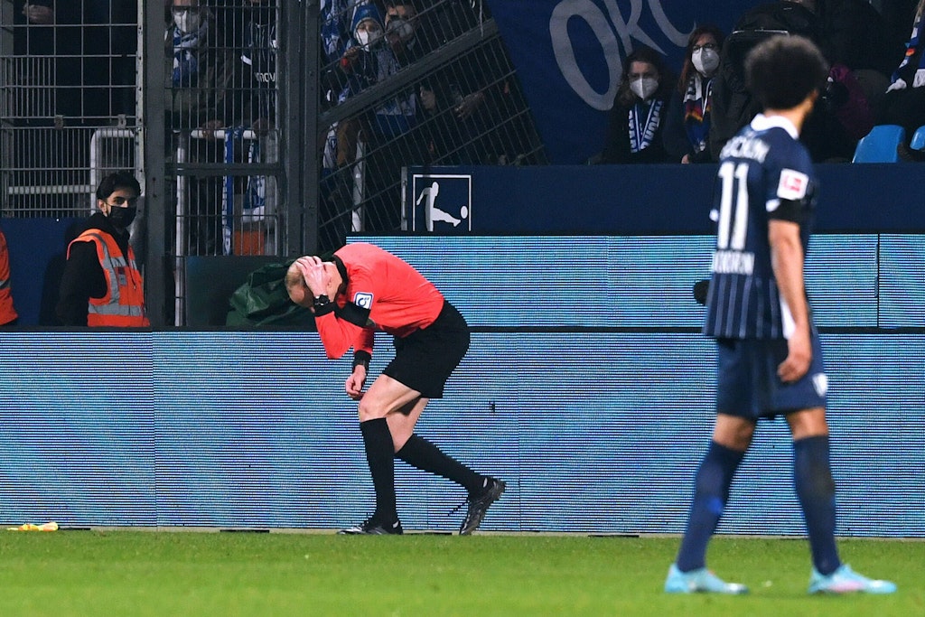 Schiedsrichterassistent Christian Gittelmann geht nach einem Becherwurf zu Boden.
