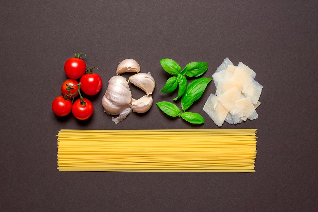 Nudeln, Tomaten, Knoblauch, Basilikum und Parmesan kommen in diesen leckeren Salat.