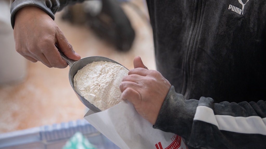 Ein Mitarbeiter füllt in der Philippi Mühle in Hessen 405er Mehl in einen 5-KG-Sack.