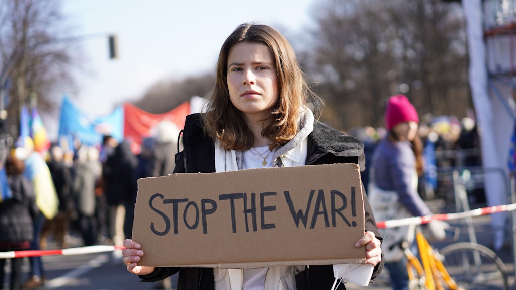 Klimaaktivistin Luisa Neubauer hält ein Schild "Stop the war!" vor einer Demonstration unter dem Motto "Stoppt den Krieg! Frieden für die Ukraine und ganz Europa" gegen den russischen Angriff auf die Ukraine.