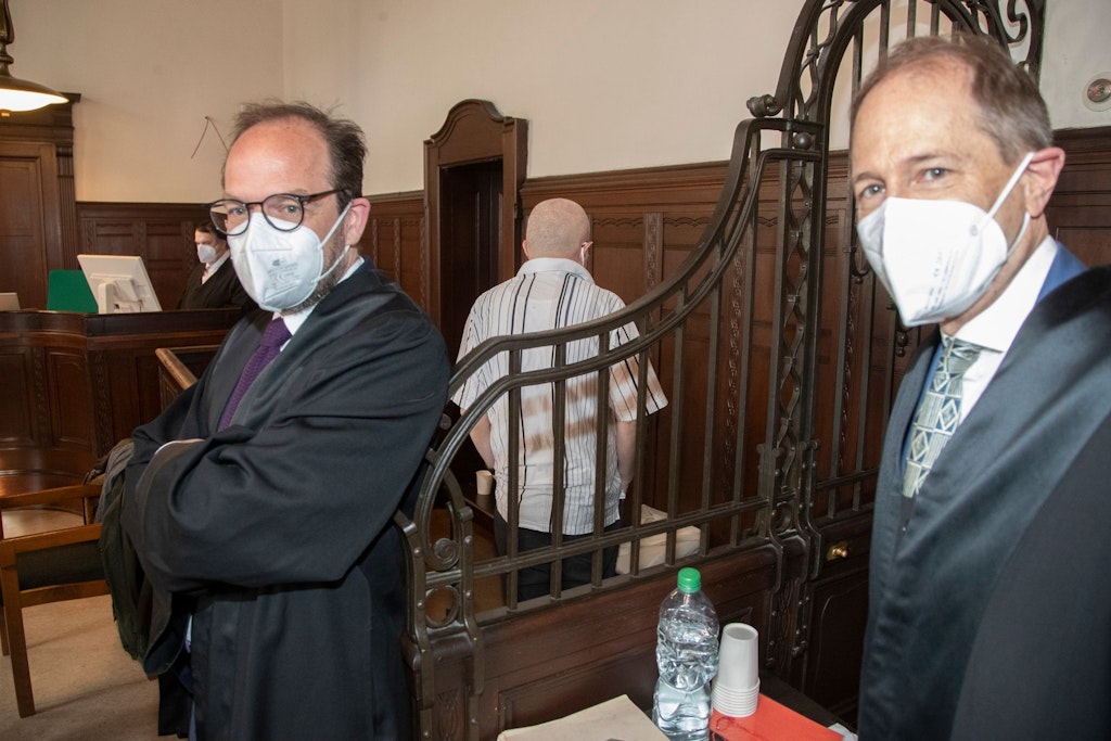 Der angeklagte Schein-Unternehmer Abdurrahim V. (53) steht abgeschirmt von seinen Anwälten zu Beginn des Prozesses am Donnerstag in Berlin.