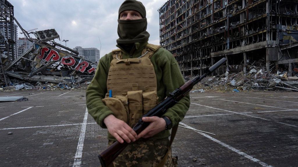 Ein Soldat steht im Krieg in der Ukraine in der Nähe eines zerstörten Einkaufszentrums.
