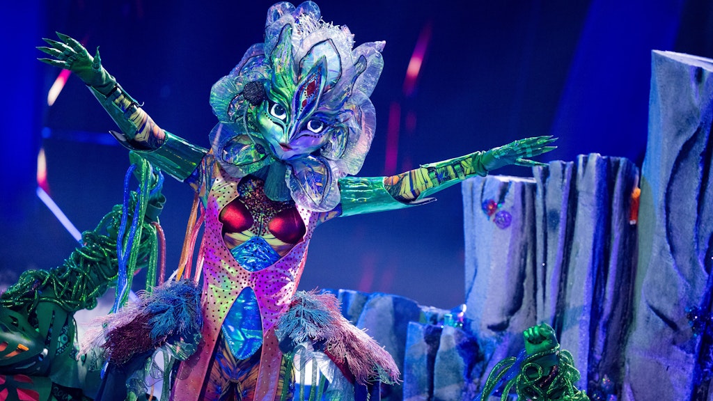Galax'sis auf der Bühne von „The Masked Singer“. Ihre Tänzer führen sie an den grünen Ranken über die Bühne.