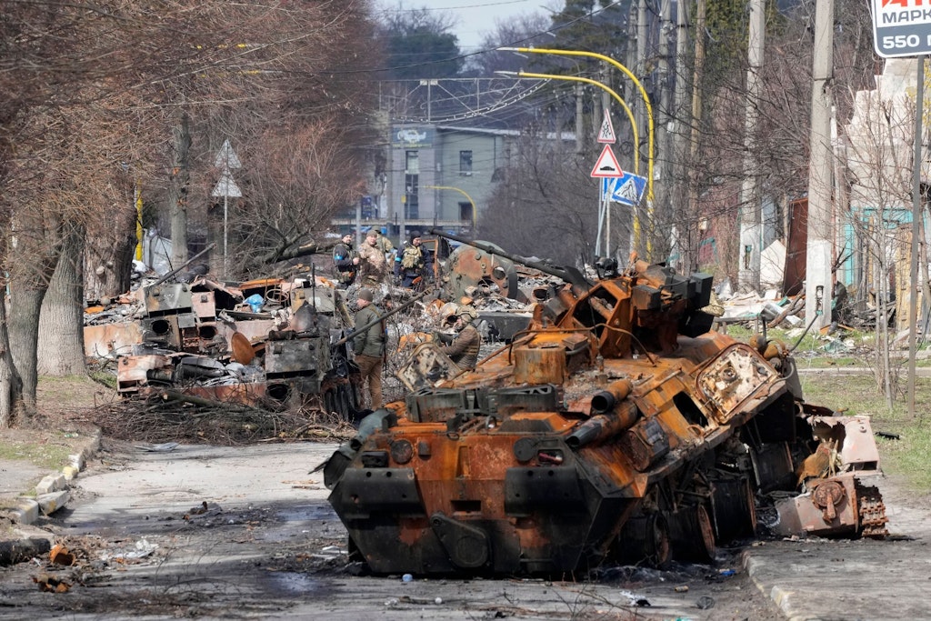 Ukrainische Soldaten untersuchen nach einem Gefecht in Butscha zerstörte russische Militärfahrzeuge.